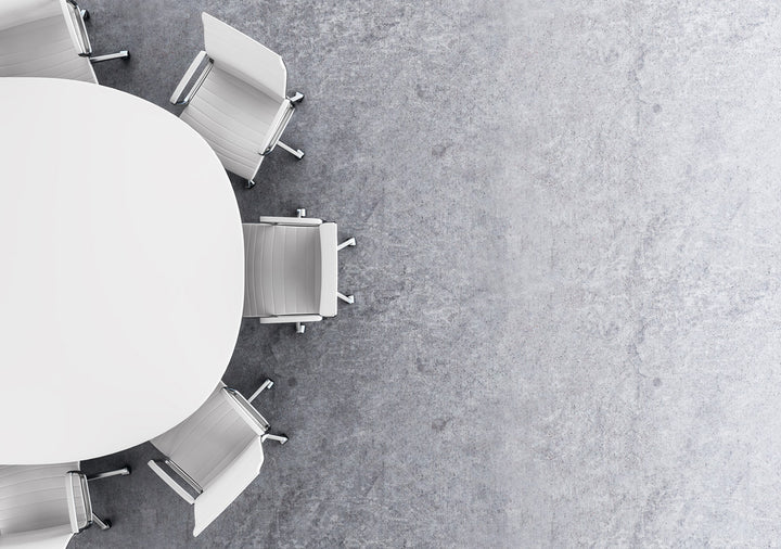 top down view of white office chairs around a white round meeting table