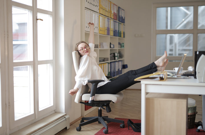 woman on a white office chair at a white office desk