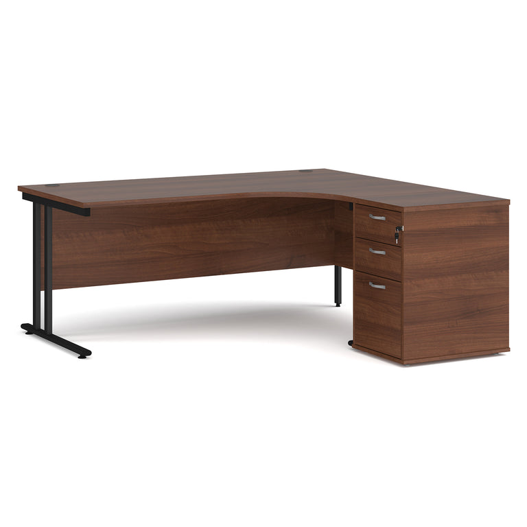 Walnut curved office desk on black cantilever, double upright legs. Alongside the desk, there is a desk high, walnut pedestal with three drawers and two keys. Walnut office furniture on white background.