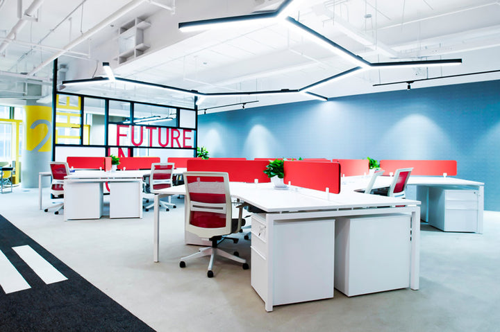 modern office interior with white bench desks red operator chairs and red separation panels